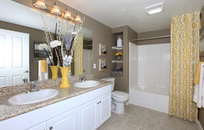 a bathroom with white cabinets and a yellow shower curtain