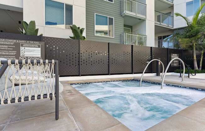 A hot tub is surrounded by a wall with a sign that reads