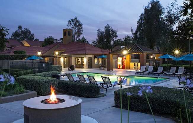 A backyard with a fire pit and a pool.