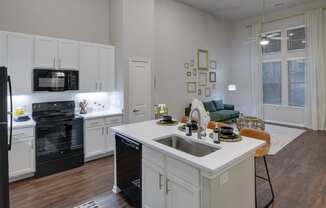 an open kitchen and living room with a sink and a counter top