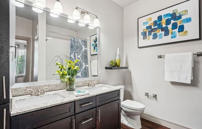 a bathroom with a large mirror and a toilet and a sink