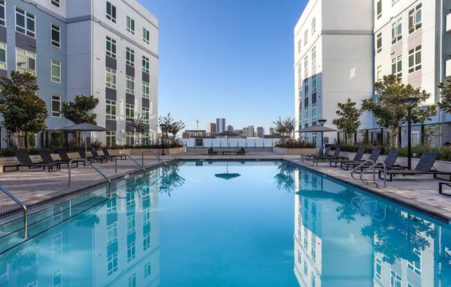 a large swimming pool in front of some tall buildings