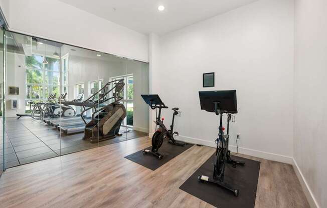 a gym with a treadmill and exercise equipment and a glass window