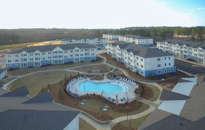 an aerial view of an outdoor swimming pool in the middle of an apartment complex