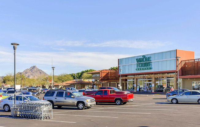 a parking lot filled with cars in front of a shopping center