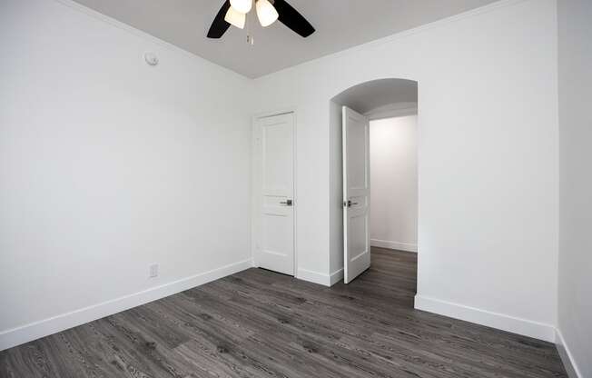 a bedroom in an empty house with a ceiling fan