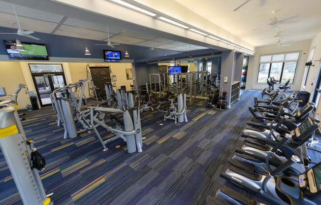 a large fitness room with cardio equipment and flat screen tvs  at Cabana Club - Galleria Club, Jacksonville, Florida