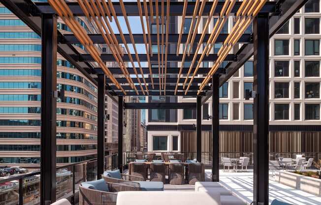A wooden pergola over a patio with white and blue couches at 365 Nicollet, Manchester