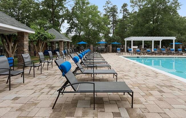 a pool with lounge chairs and umbrellas at Trails at Short Pump Apartments, Richmond, VA