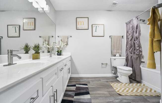 a bathroom with a toilet and a sink and a shower