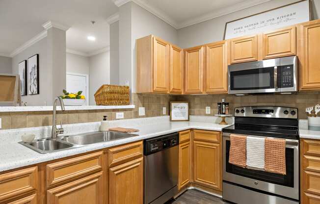 a kitchen with wooden cabinets and stainless steel appliances at The Verandah, Austin, 78726