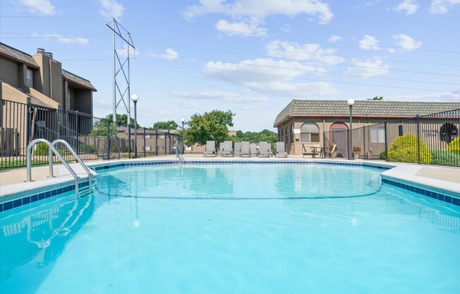 A swimming pool in a residential area with a clear blue sky.