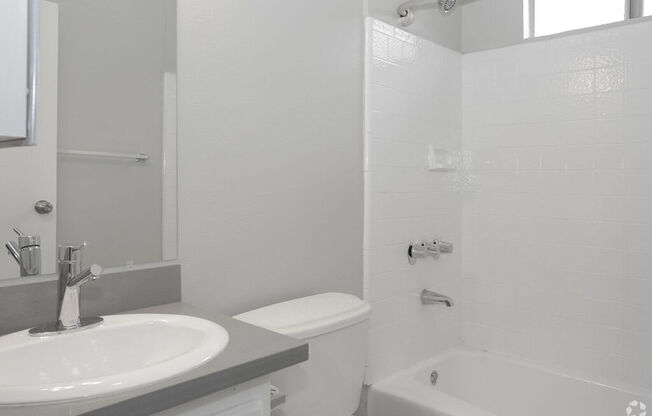 a white bathroom with a sink and a toilet at The Marq Apartments LLC, Los Angeles