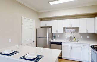a kitchen with white cabinets and a stainless steel refrigerator