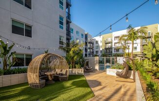 A patio area with a wicker chair and a table.