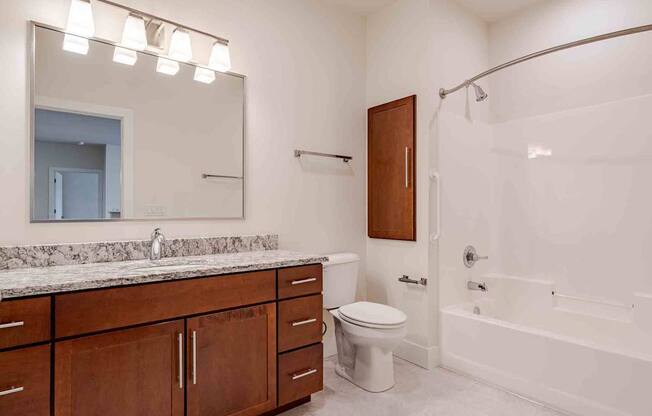 A bathroom with a white tub, sink, and toilet.