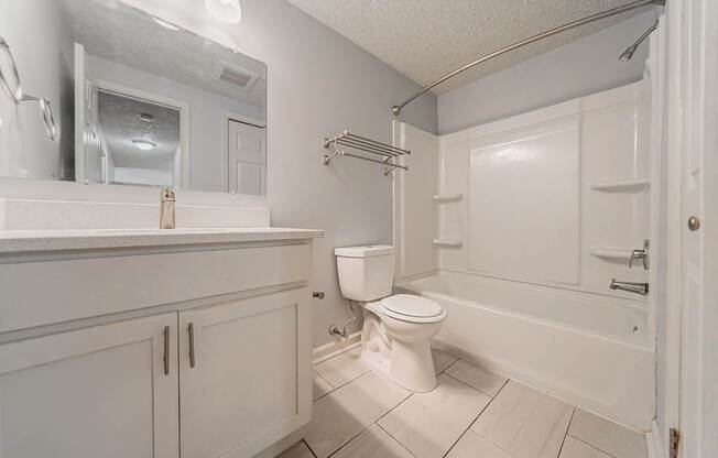 A white bathroom with a toilet, sink, and bathtub.