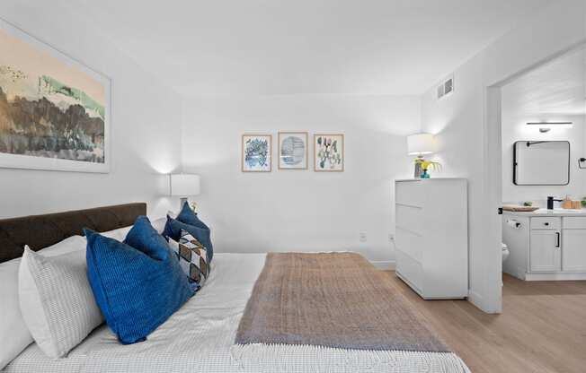 a bedroom with a bed with blue pillows and a rug