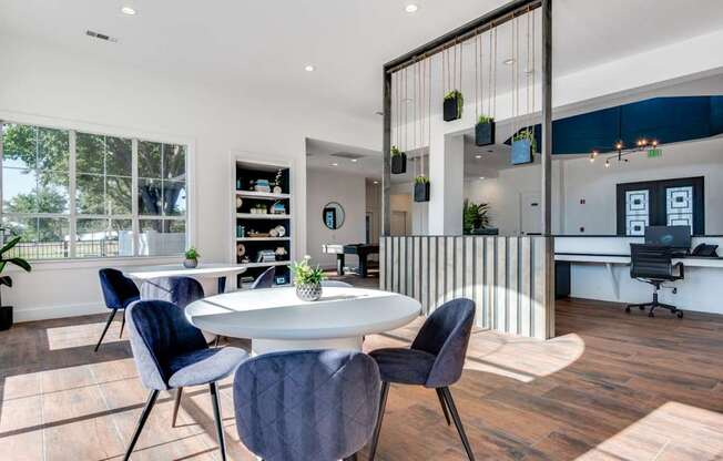 A modern dining room with a white table and blue chairs.