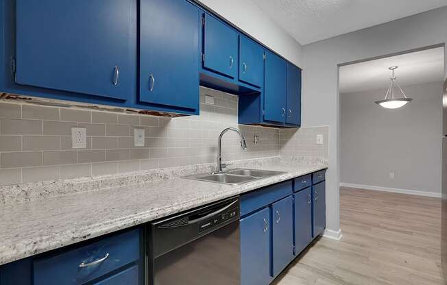 A kitchen with blue cabinets and a marble countertop.