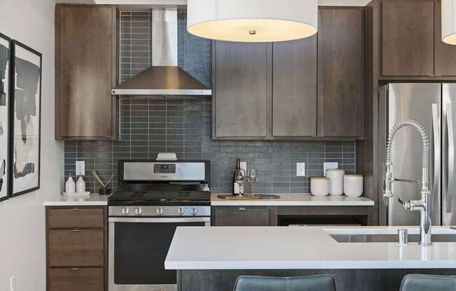 A modern kitchen with a stove, sink, and cabinets.