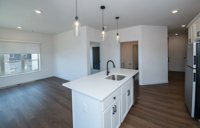 a kitchen and living room with white cabinets and a white counter top at The Crossings at Windsong, Arizona, 86314