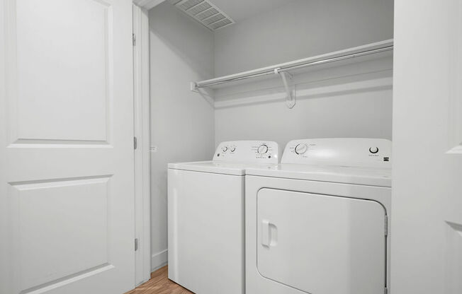 a laundry room with a washer and dryer and a white door