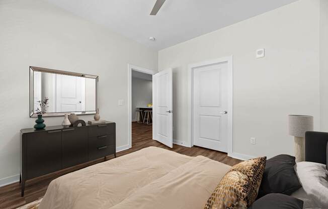 A bedroom with a bed, dresser, and mirror.