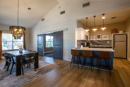 A modern kitchen with dark wood floors and a dining table with chairs.