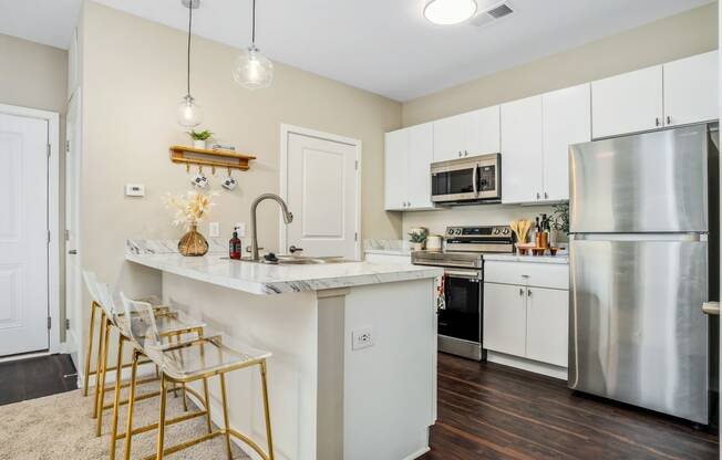 a kitchen with stainless steel appliances and a marble counter top