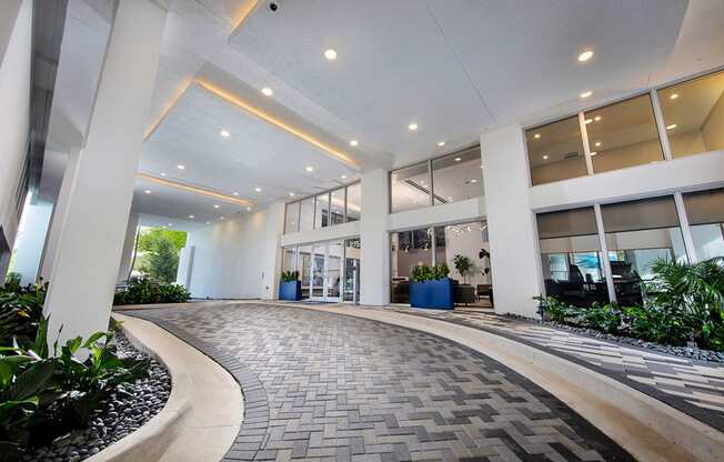 an office lobby with windows and a walkway with plants at Saba Pompano Beach, Pompano Beach, 33062