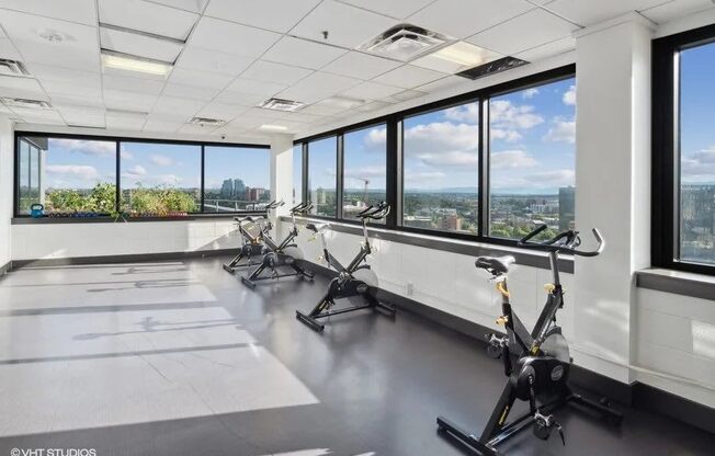 A gym with exercise bikes and a view of the city at Archer Tower in Denver, CO