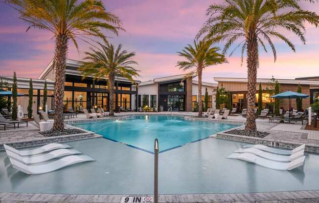 a large swimming pool with palm trees in front of a building