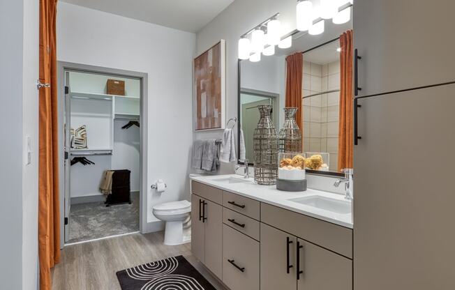 a bathroom with a large mirror and a sink and a toilet at Aura Stonebridge, Virginia