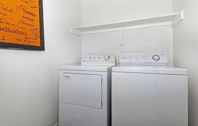 a washer and dryer in a white room with a sign on the wall