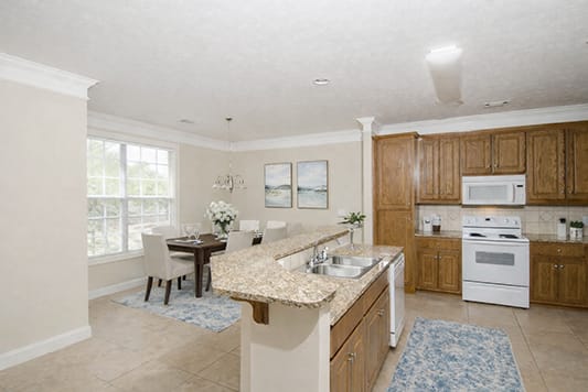 A kitchen with a table and chairs in front of a window.