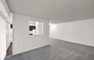 a large empty room with white walls and a tile floor