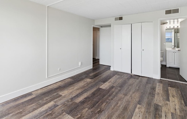 an empty living room with white walls and wood flooring