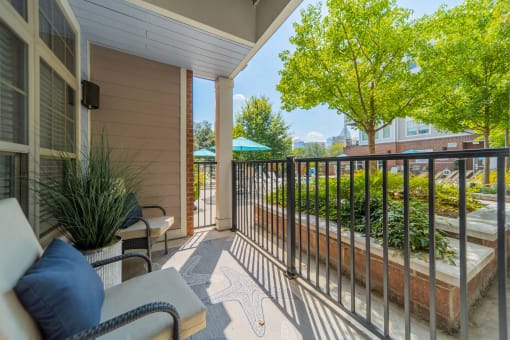 a balcony with a view of a garden and a patio