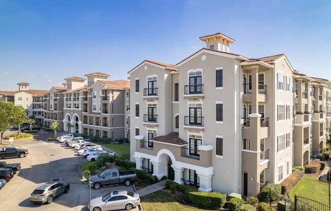 A large apartment complex with multiple buildings and cars parked in the driveways.
