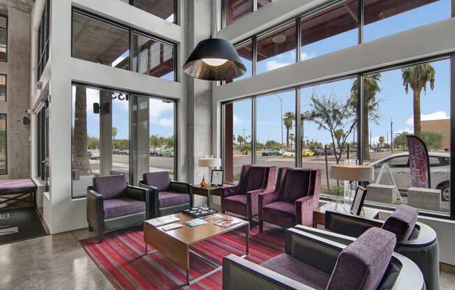 a lobby with purple chairs and a red rug