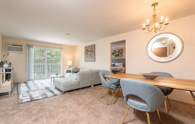 Two bedroom common area living room with balcony and dining space with plush carpeting