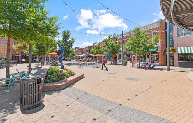 A sunny day in a pedestrian plaza with a person walking.