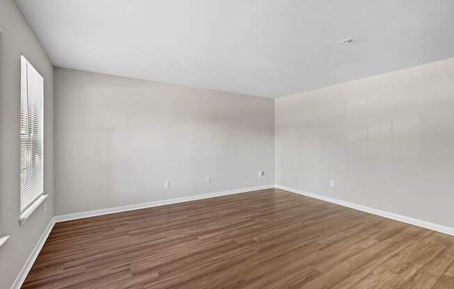 A room with wooden flooring and white walls.