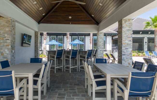 A patio with tables and chairs and umbrellas.