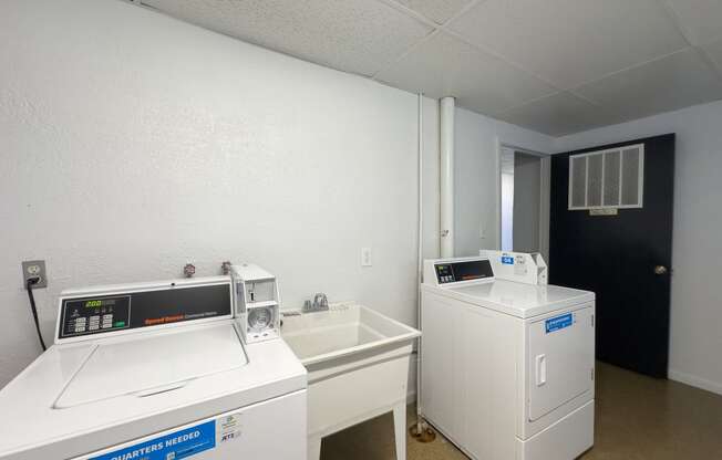 a laundry room with two washing machines and a sink