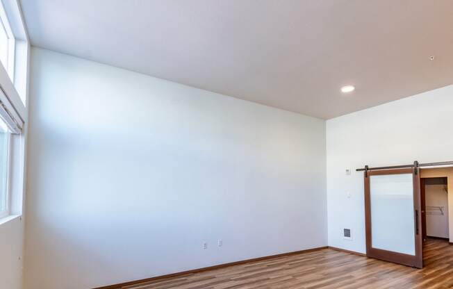 an empty living room with white walls and a sliding glass door