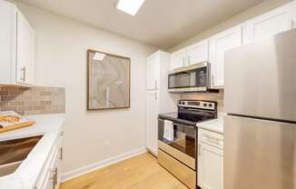 a renovated kitchen with stainless steel appliances and white cabinets