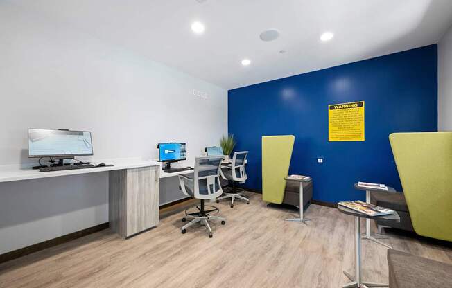A room with a blue wall and a computer on a desk.
