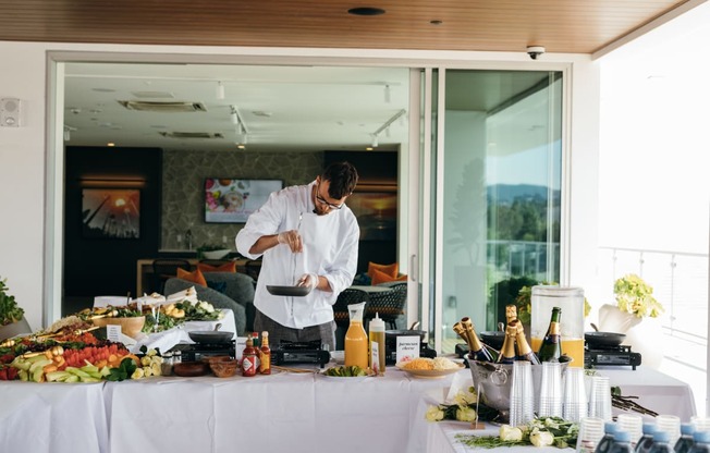 a man in a white shirt is preparing food on a table